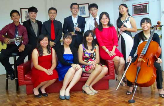PASSIONATE MUSICIANS: The students who will be performing at the school’s in-house recital share a light moment with Law (fifth right).